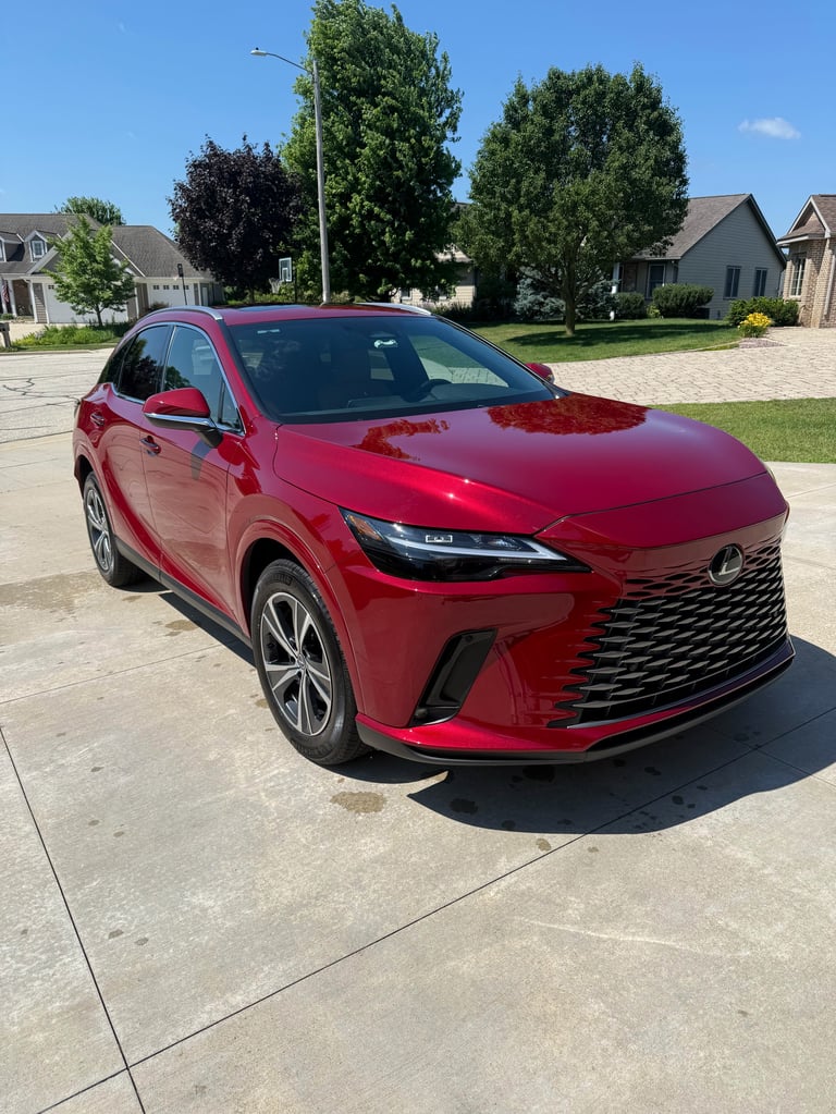 Red Lexus SUV parked on a residential driveway with trees and houses in the background